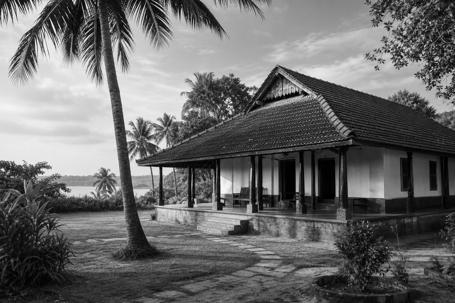 Traditional coastal Mangalorean home surrounded by a garden and coconut palms
